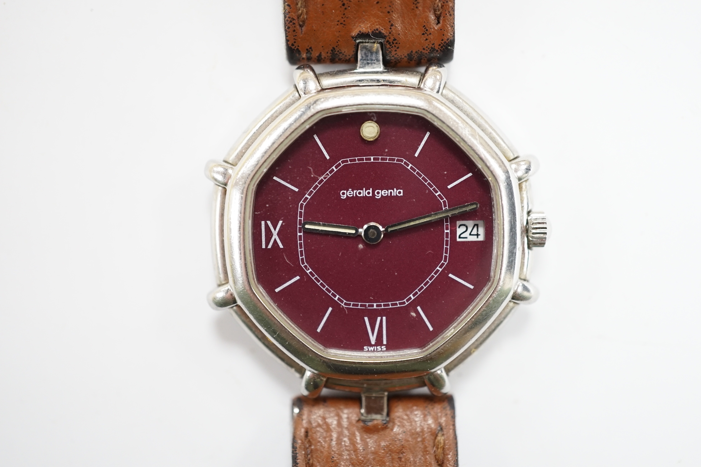 A gentleman's Swiss stainless steel Gerald Genta quartz octagonal wrist watch, with burgundy dial and Roman and baton numerals, on a leather strap, case diameter 32mm, with original box, leather pouch and guarantee.